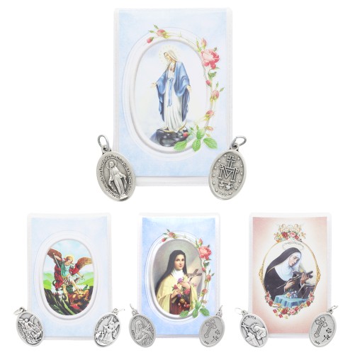 Médaille métal couleur argentée forme ovale H. 2,2 cm dans pochette avec image. Plusieurs saints