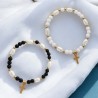 Bracelet sur elastique avec grains ovales en acrylique et grains ronds, agremente d une croix en metal doree. LOT DE 2